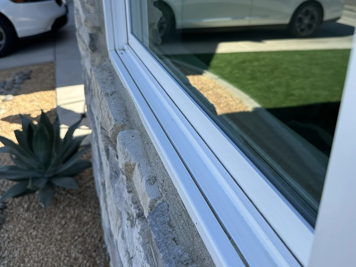 A spotless front window and clean sill track after a deionized-water wash